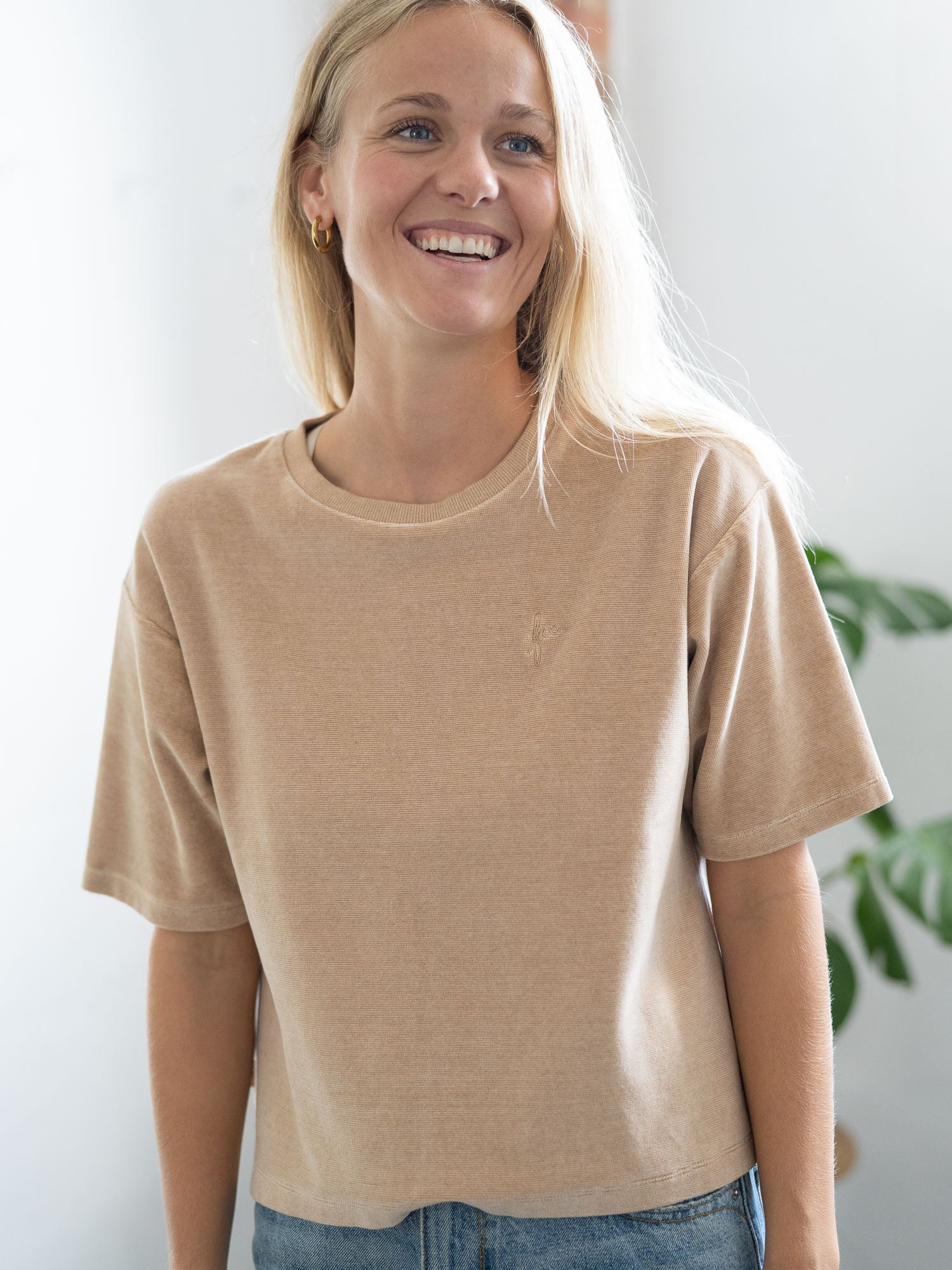 Greta trägt das nachhaltige und faire Frauen Cropped Samt T-Shirt in beige gelb geriffelt von FUXBAU aus 100% Biobaumwolle