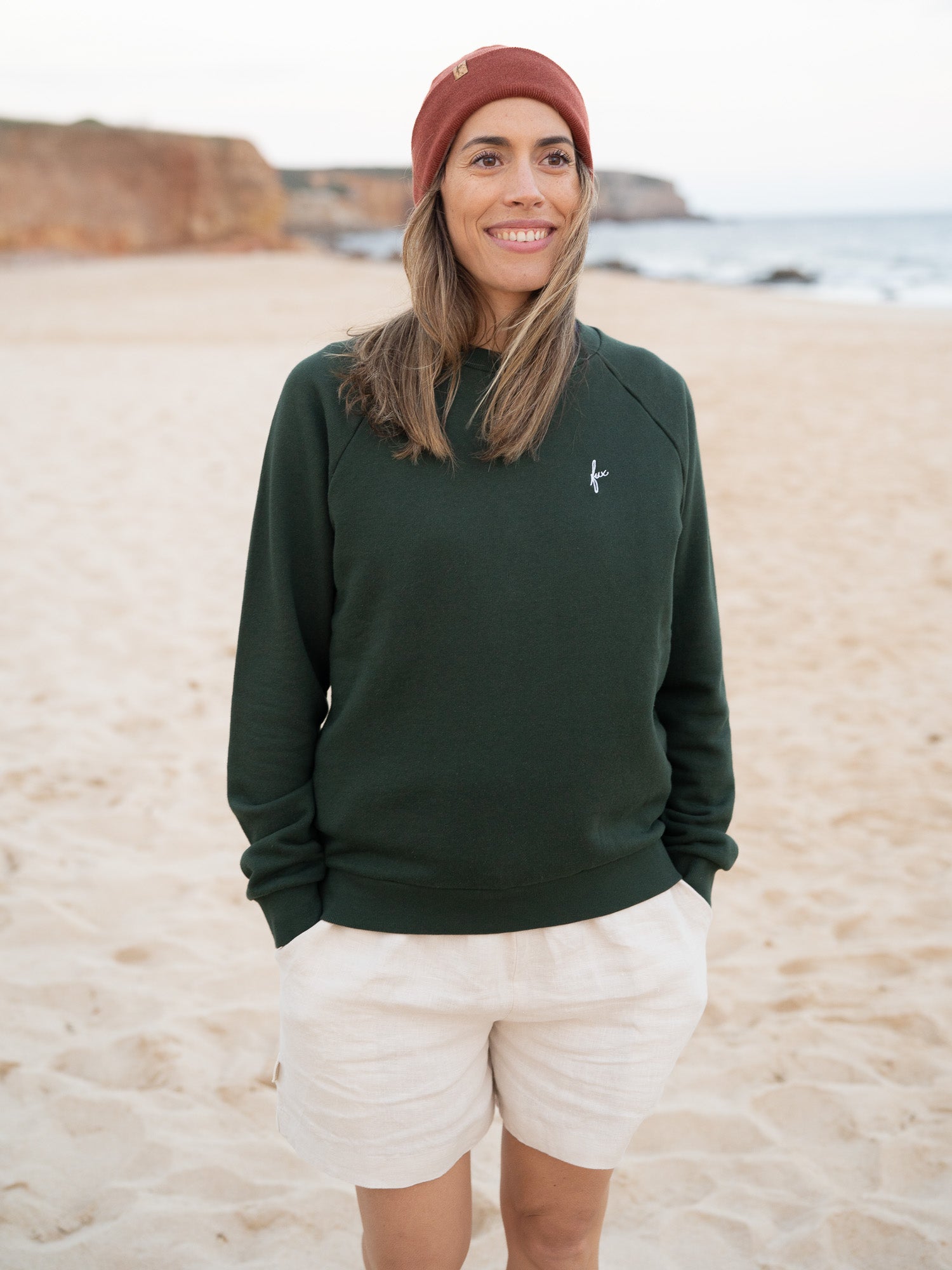 Nachhaltige Fair Fashion Frauen Leinenshorts in cremeweiss von FUXBAU Made in Portugal aus 100% Leinen getragen am Strand in Portugal.