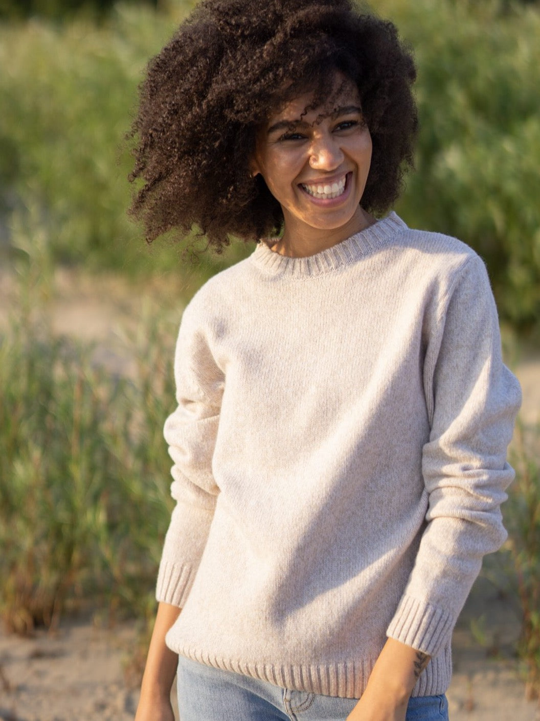 Jacky trägt unseren Fair Fashion Frauen Merino Strickpullover in beige aus 100% Merinowolle und fair in Deutschland hergestellt